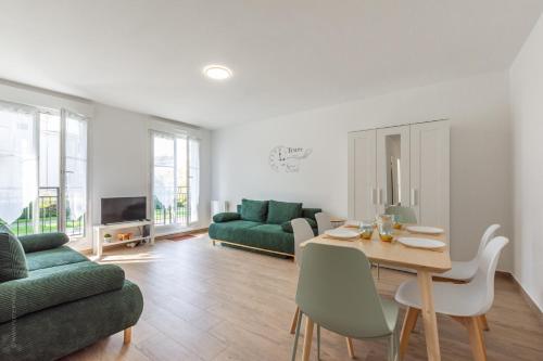a living room with a table and a green couch at BIG BEN Near Disneyland Paris - Fairytale Factory in Bussy-Saint-Georges