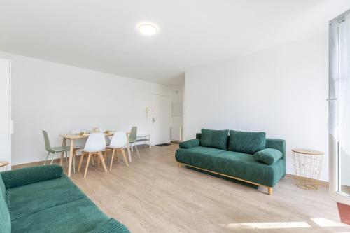 - un salon avec deux canapés verts et une table dans l'établissement BIG BEN Near Disneyland Paris - Fairytale Factory, à Bussy-Saint-Georges