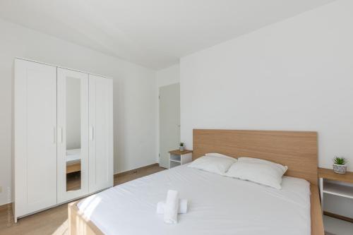 - une chambre blanche avec un grand lit blanc et des oreillers blancs dans l'établissement BIG BEN Near Disneyland Paris - Fairytale Factory, à Bussy-Saint-Georges