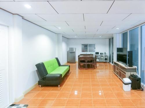 a living room with a green couch and a television at AURA Park Resort in Ban Thung Sam Sao