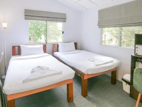 two beds in a room with two windows at AURA Park Resort in Ban Thung Sam Sao