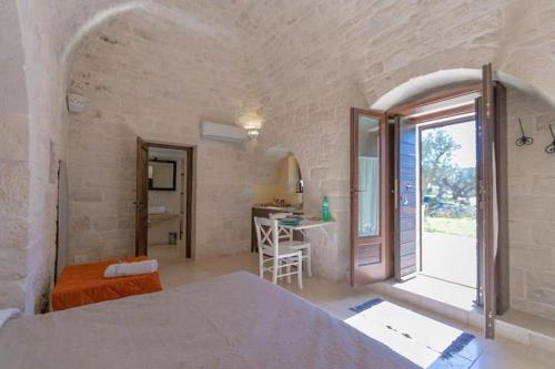 a bedroom with a bed and a room with a table at Lunalì in Alberobello