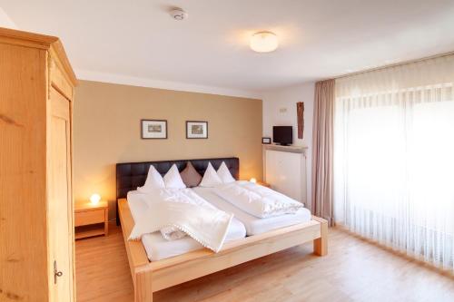 a bedroom with a large bed with white pillows at Haus Schmölz Ferienwohnung Allgäu in Hopferau