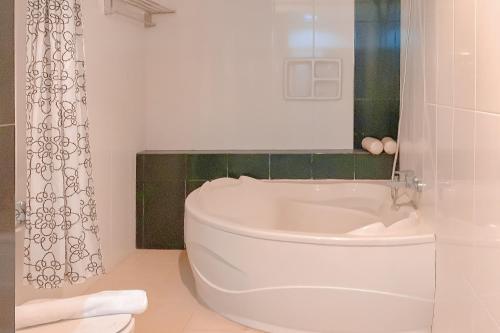 a white toilet in a bathroom with a shower at Urbanview Hotel Grand Permata In Banjarbaru by RedDoorz in Ulin