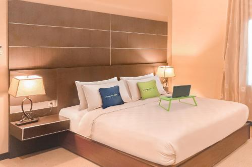Кровать или кровати в номере Urbanview Hotel Grand Permata In Banjarbaru by RedDoorz
