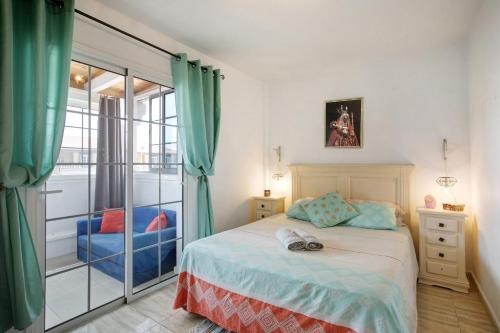 a bedroom with a bed and a sliding glass door at Arenas del Mar in El Médano