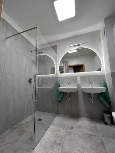 a bathroom with two sinks and a shower at Apartament U Wujka Żukowo in Żukowo