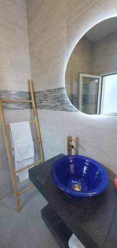 a bathroom with a blue sink and a mirror at APARTAMENTOS LA PALMERA in Fernán Pérez