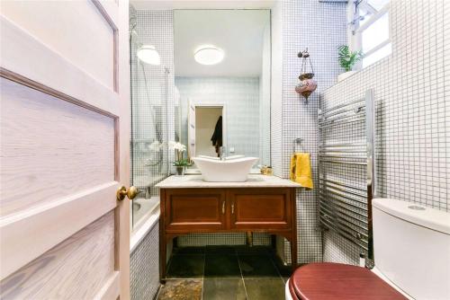 a bathroom with a sink and a toilet and a mirror at Designer Flat in Bethnal Green in London