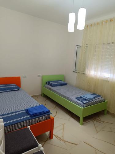 una camera con due letti e uno specchio di Vlora 3D Guesthouse a Vlorë