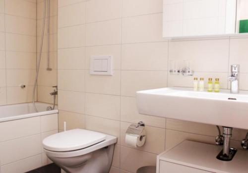 een witte badkamer met een toilet en een wastafel bij Nest - Lauriedstrasse 1 in Zug