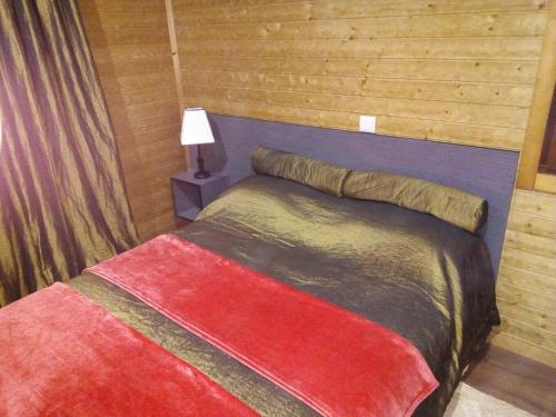 1 dormitorio con 1 cama con pared de madera en Douro Camping, en Miranda do Douro