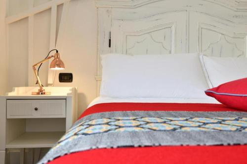 a bedroom with a red bed with a white headboard at Lughia in Tortolì