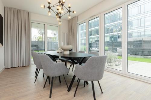 a dining room with a black table and chairs at LUX Apartments Domaniewska with Sauna & Gym by Renters Prestige in Warsaw
