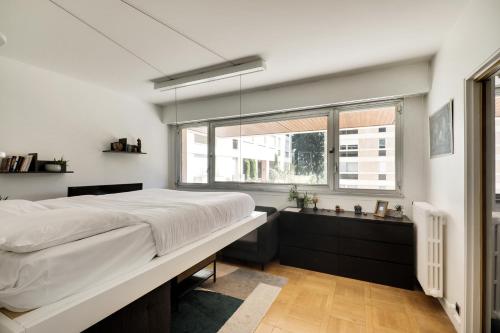 a bedroom with a large bed and a window at Le Nid- Garches in Garches