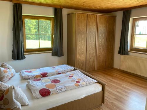ein Schlafzimmer mit einem Bett und zwei Fenstern in der Unterkunft Arlberggut in St. Johann im Pongau