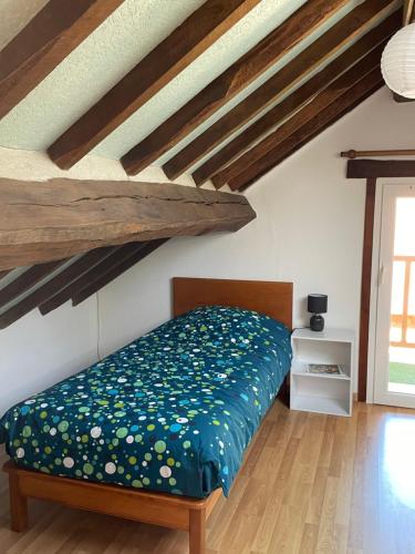 um quarto com uma cama num quarto com tectos em madeira em Gîte les érables em Forléans