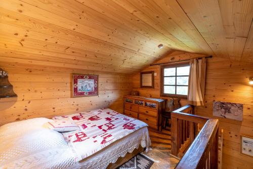 a bedroom with a bed in a wooden cabin at Chalet du Brey - Avec terrasse et jardin in Saint-Gervais-les-Bains