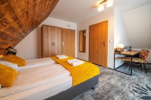 a bedroom with a large bed and a desk at Malinowy Potok in Białka Tatrzanska