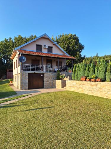 a house with a garage and a grass yard at Apartmani Milosavljević in Kuršumlija