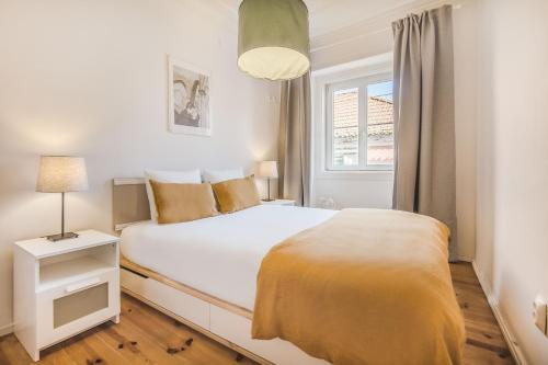 - une chambre avec un lit blanc et une fenêtre dans l'établissement Lisbon City Stay @ Largo do Carmo, à Lisbonne