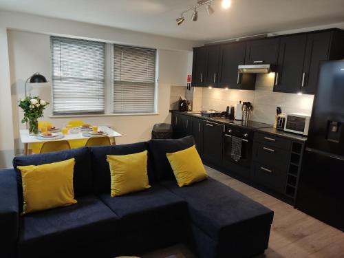 a living room with a blue couch and a kitchen at 3-Bed Cottage - fast WiFi-Big Garden - Town Centre in Kirriemuir