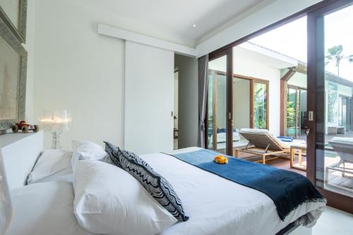 um quarto com uma grande cama branca e um pátio em Villa Maz Canggu em Canggu