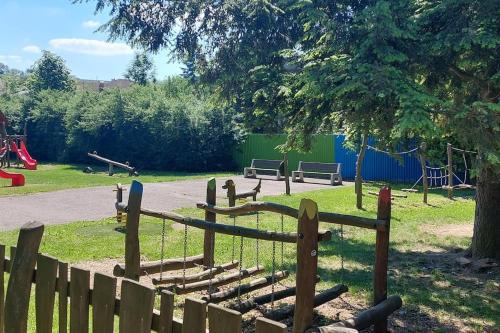 a park with a wooden fence and a playground at Apartmán Budín - v klidu přírody, s parkováním in Nové Město nad Metují