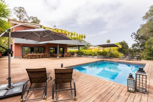 una piscina con due sedie e un ombrellone di Casa de lujo junto al Club Golf a Tacoronte