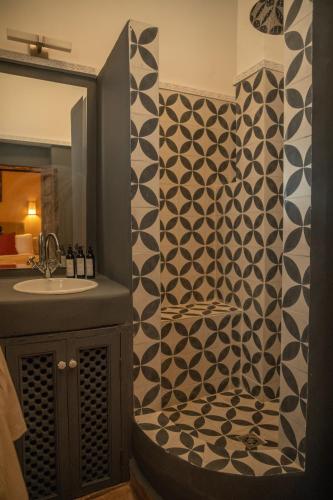 a bathroom with a black and white patterned shower curtain at Riad Le Petit Bacha in Marrakesh