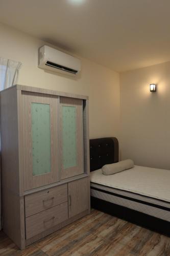 um pequeno quarto com uma cama e uma cómoda e aversão em The Somer Campsite em Karak