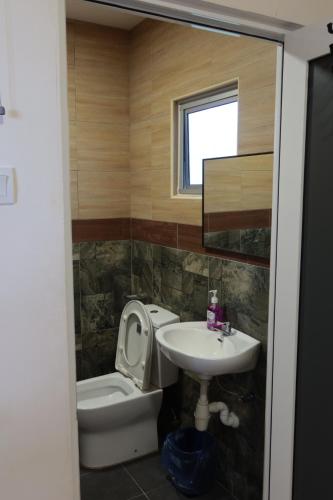 een badkamer met een toilet en een wastafel bij The Somer Campsite in Karak