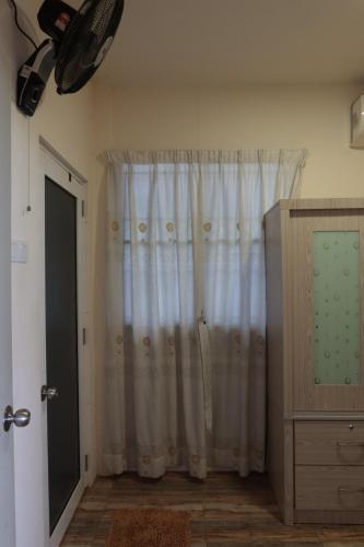 um quarto com uma cortina, uma cómoda e uma janela em The Somer Campsite em Karak