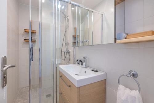 une salle de bain blanche avec un lavabo et une douche dans l'établissement Denfert Rochereau - Wonderful apartment near the Parc des Princes, à Boulogne-Billancourt