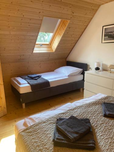 - une chambre avec 2 lits et une fenêtre dans l'établissement Domki Błażejewo, à Łukęcin