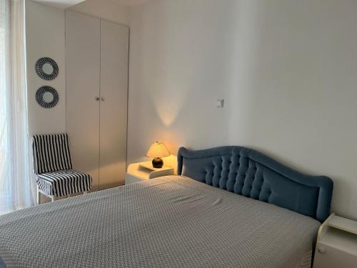 um quarto com uma cama azul e uma cadeira em Lovely getaway in Ohrid em Ohrid