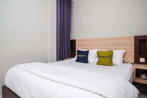 a bedroom with a large white bed with two pillows at Urbanview Stay at H jakal by RedDoorz in Yogyakarta