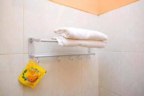 a towel rack in a bathroom with towels at Urbanview Stay at H jakal by RedDoorz in Yogyakarta