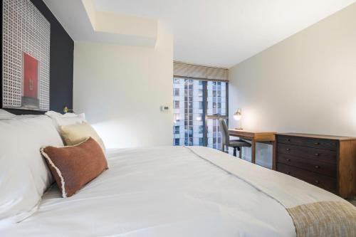 a bedroom with a white bed and a desk at Loop 1BR w Gym Pool nr Financial District CHI-211 in Chicago