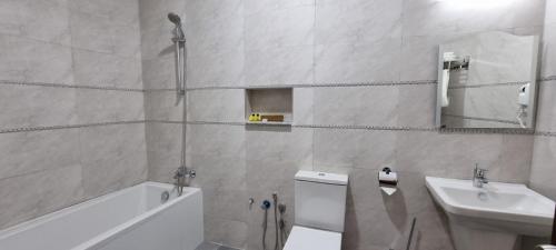 a bathroom with a sink and a toilet and a mirror at Sheek Hotel in Erbil