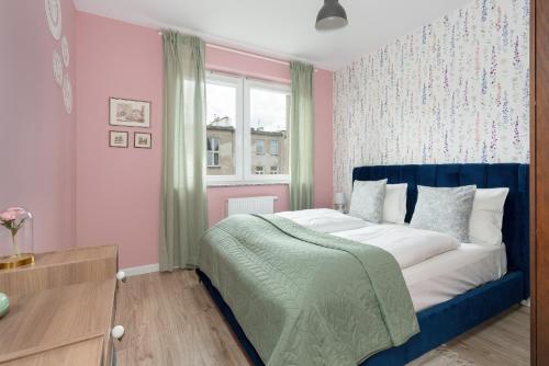 a bedroom with a blue bed and a window at Elegant Pastel Apartment with Balcony Nadodrze by Renters in Wrocław
