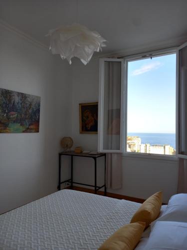 a bedroom with a bed and a large window at Amazing view - Monaco in Cap d'Ail