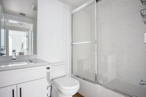 a bathroom with a toilet and a glass shower at Mid-Wilshire 2br w roof terrace nr shopping LAX-1121 in Los Angeles