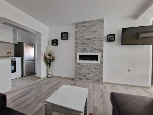 ein Wohnzimmer mit einem gemauerten Kamin und einem Tisch in der Unterkunft Apartment ''Simon Green'' in Baltschik