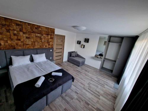 ein Schlafzimmer mit einem großen Bett und einem Stuhl in der Unterkunft Apartment ''Simon Green'' in Baltschik