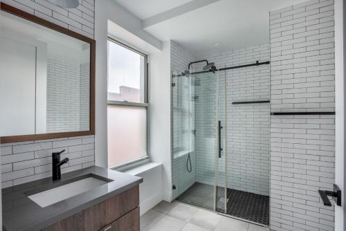 La salle de bains est pourvue d'une douche en verre et d'un lavabo. dans l'établissement East Village 3br w elevator wd nr parks NYC-1209, à New York