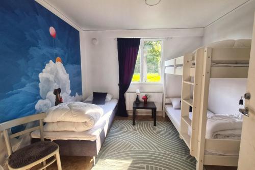 ニュブルーにあるOrrefors Vandrarhemのベッドルーム1室(二段ベッド2台、壁画付)