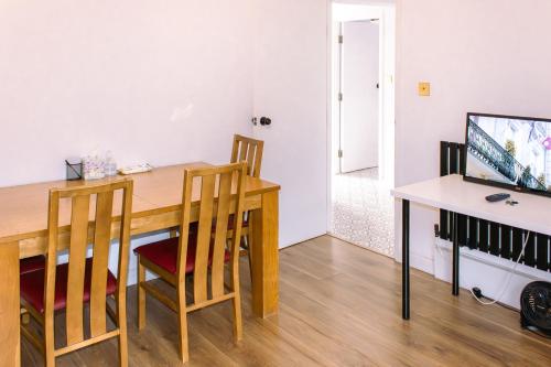 comedor con mesa de madera y escritorio en Nice 4 Bedroom Apartment near City Centre 2-min Walk to Metro !! Business & Family Friendly!!, en Londres