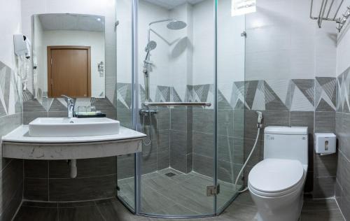 a bathroom with a toilet and a sink and a shower at Tung Quang Hotel in Cat Ba