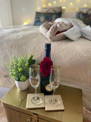 a bed with a bottle of wine and two glasses at LOVER'S ROOM TROPIC in Verton